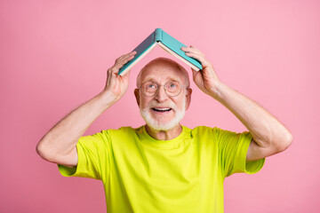 Portrait of cute optimistic pensioner read copybook on head wear spectacles green color t-shirt...