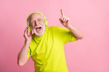 Photo of singing optimistic old man listen music dance wear headphones spectacles lime color...