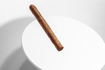 Creative Still Life Image Featuring A Large Cigar Floating and Isolated In A White Space.