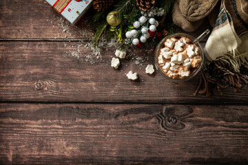 Christmas presents and hot cocoa with marshmallows on the wooden table. Top view with copy space.