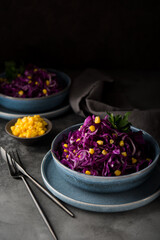 Fresh vegetarian salad with red cabbage and corn on a dark background