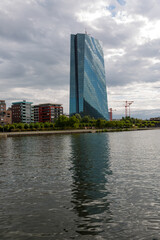 Main building of European Central Bank near to the river and cloudy sky