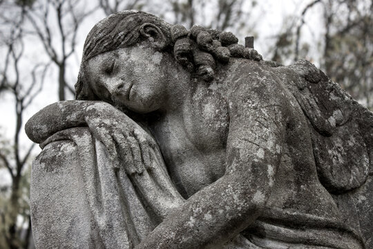 Woman angel crying in the cemetery. Death and suffering