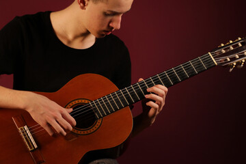 Young man playing classic acoustic guitar