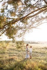 You will be a big brother. A pregnant mother with a school age son hugging outdoors