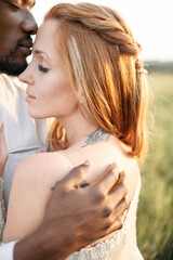 Close-up portrait of diverse couple in love. A gentle african man is kissing beautiful redhead woman