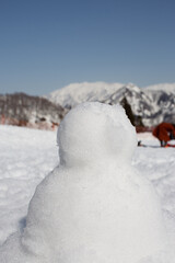 Made of white snow, blurred background with natural mountain views.