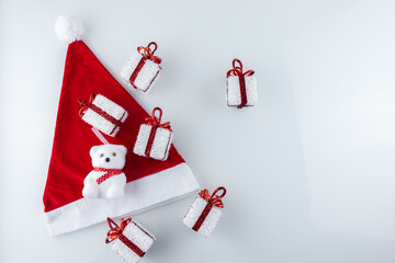 Christmas gift boxes with ribbon are placed on Santa's hat