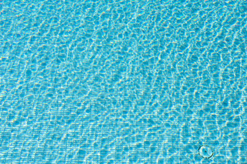 Surface of blue swimming pool,background of water in swimming pool. Ripple Water in swimming pool with sun reflection