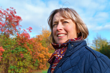 portrait of a woman posing in autumn park, bright colorful leaves as background