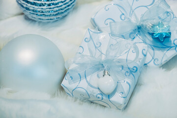 Fototapeta na wymiar Cadeau de Noël emballé avec du papier blanc bleu et joli ruban turquoise - Décoration de fêtes de Noël