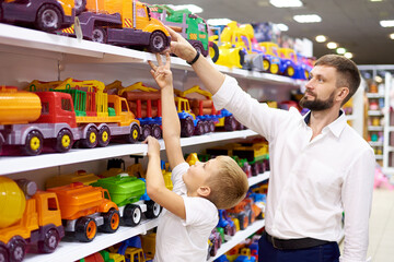 Father and son purchase a toy car in a toy store.