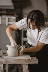 Fototapeta na wymiar Female potter making a clay jug.