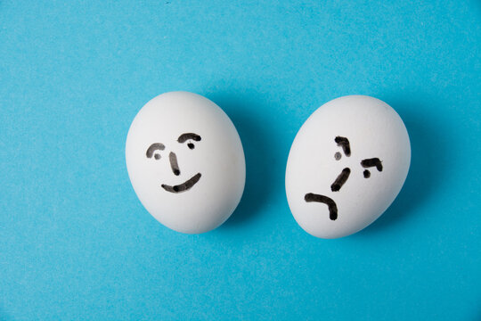 Eggs with faces and different emotions. Isolate on a blue background. The concept of joy and resentment