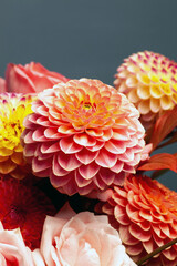 Floral composition of dahlia flowers, roses and autumn leaves. Arty, bright red and pink color  bouquet of flowers on blue background 