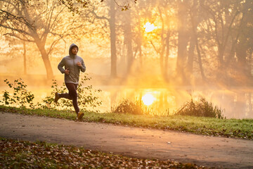 Runner in the park during autumn fall sunny morning