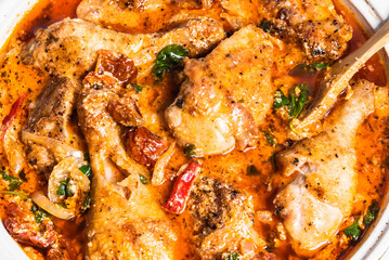 Cooking Tuscan chicken with sun-dried tomatoes, tomato paste, spinach, cream and cheese in a pan.