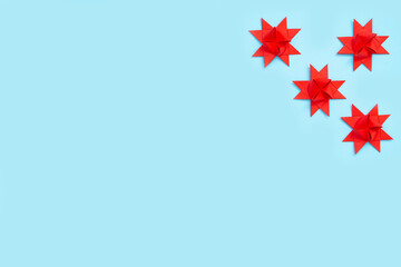 Origami paper stars on a pastel blue background. Minimal festive composition. Copy space for text.