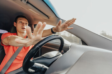 Naklejka premium Fear of young man driving car at high speed. Accident on road. Shock and panic emotions on face of people inside vehicle