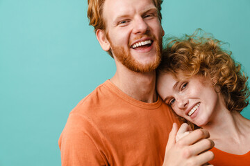 Young happy redhead couple smiling and hugging at camera