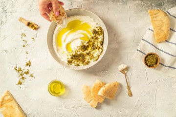 Popular middle eastern appetizer labneh or labaneh, soft white goat milk cheese with olive oil,...