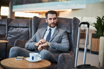 Business professional is winding up his watch
