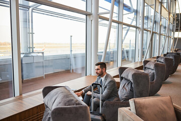 Man leaning over a table from a cozy armchair