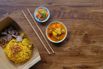 Roasted meat served with rice , dalca and sour sauce . This food is well-known in the Northern Peninsular Malaysia known as 