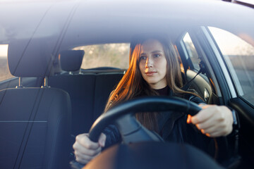 Young woman driving rented car in the evening