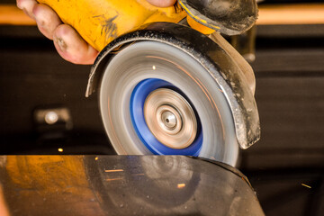 Cutting steel with angle grinder at car service