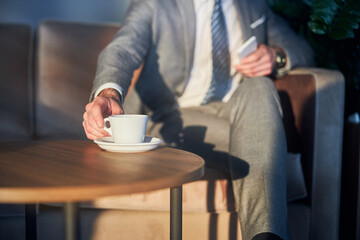 Adult male closing his fingers on a cup handle