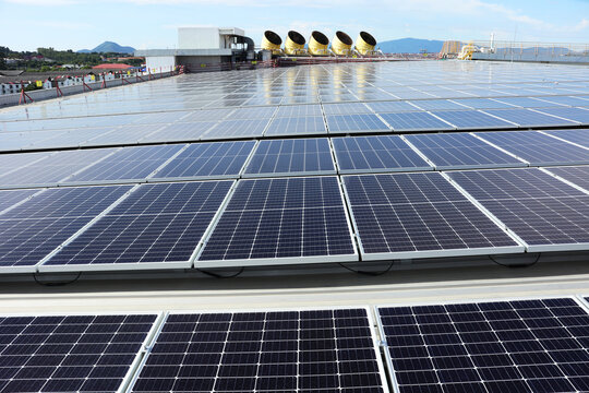 Solar PV System on Industry Roof with Cooling Towers Background
