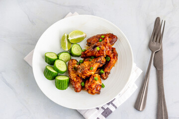 Thai Baked Chicken Wings with Cucumber and Lemon Directly Above Horizontal Photo