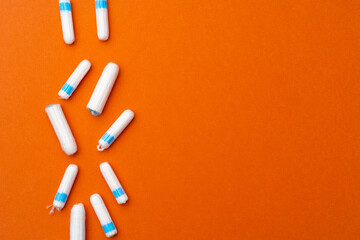 Medical female tampons on orange background top view