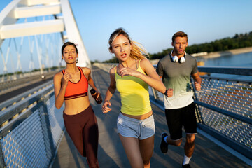 Fitness, sport, people and running concept. Happy fit friends running outdoors