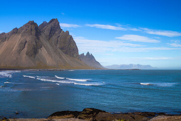 Majestic place: Vestrahorn, East Iceland. Blue Atlantic ocean, black sand beach and mountains.