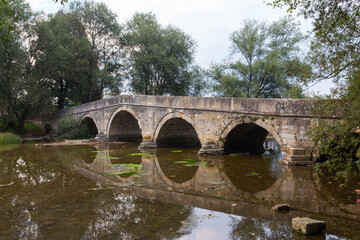 Fototapeta na wymiar Historic stone Roman bridge in Vrelo Bosne Park near Sarajevo. Bosnia and Herzegovina