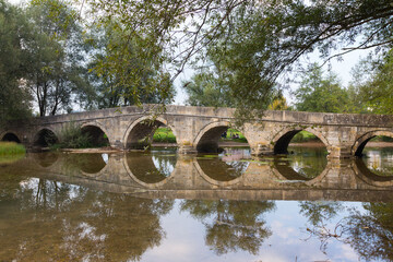 Fototapeta premium Historic stone Roman bridge in Vrelo Bosne Park near Sarajevo. Bosnia and Herzegovina