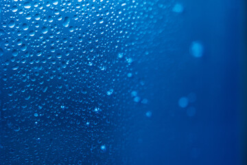 Naklejka na ściany i meble Water Drops on a Glass, Blue Surface. Science and Cosmetics Background. Concept of Hydration. Full Frame Shot. High Resolution Photography.