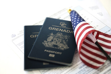 two Grenada passport beside USA flag - obrazy, fototapety, plakaty
