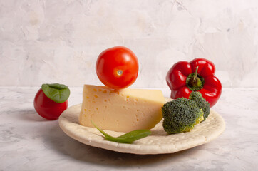 Ingredients for making pizza. Dough, broccoli, tomato, pepper, spinach. Against the background of gray plaster.