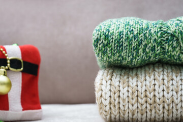 a stack of warm knitted clothes and Christmas decorations