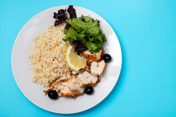 chicken with boiled rice and salad on white plate