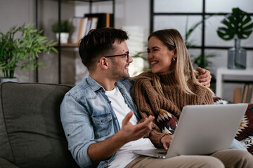 Happy young couple with laptop at home