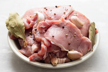 raw pork with black pepper, garlic and bay leaf on dish