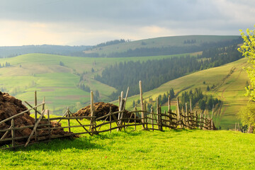 Spring morning rural landscape in the Carpathian mountains with fence