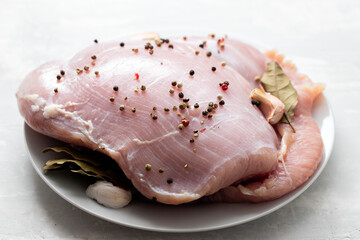 raw turkey with black pepper and garlic on dish