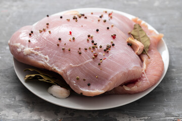 raw turkey with black pepper and garlic on dish