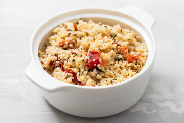 tabbouleh on small white bowl on ceramic background