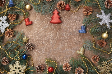 Christmas decorations, branches with cones, toys, on a brown background. With space for text. New year background.